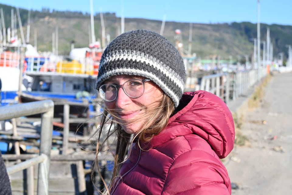 Anja steht im Hafen von Lebu und der Wind weht ihr die Haare ins Gesicht