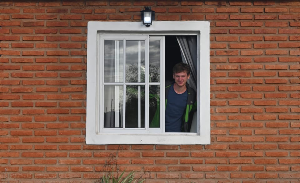 Pascal wirft einen Blick aus unserer Unterkunft durch ein Fenster.