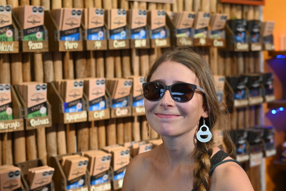 Anja steht vor einem Regal voll mit Schokoladentafeln im Choco-Museum.