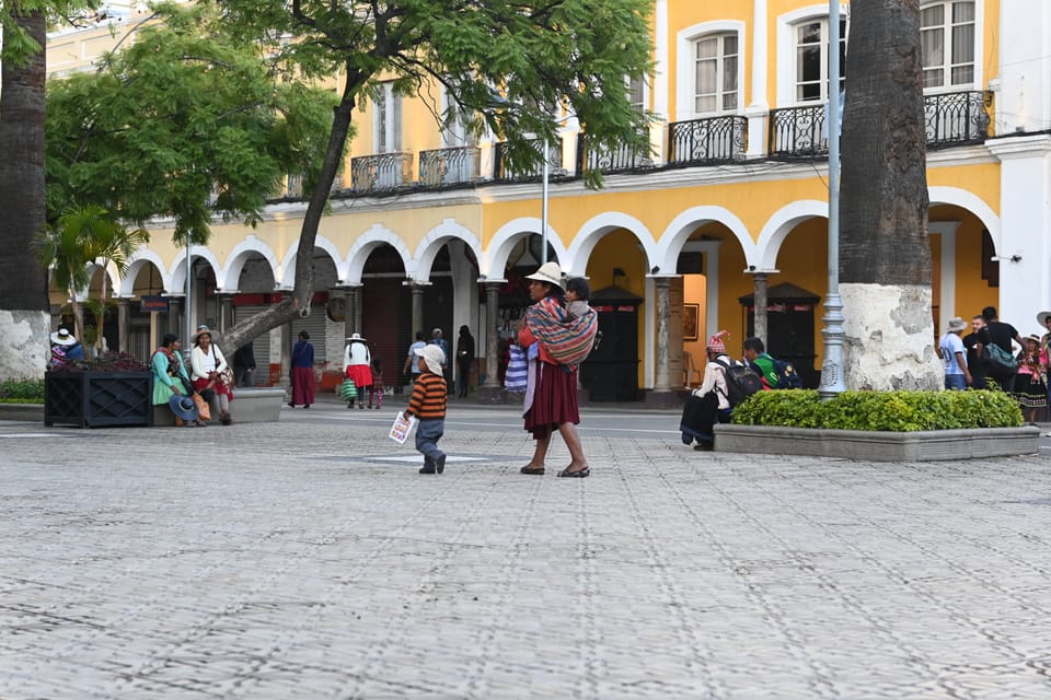 Traditionell gekleidete Mutter mit Kindern am Marktplatz.