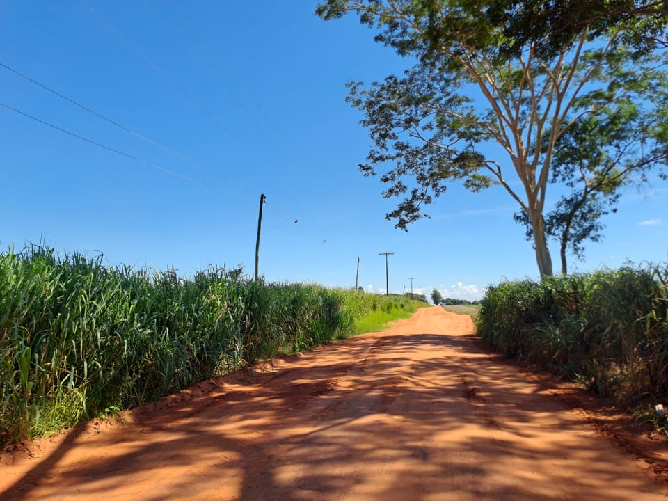 Eine Sandstraße im Hinterland, bei brutzelnder Sonne.