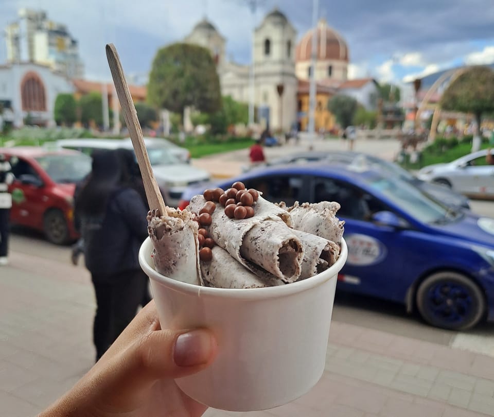 Ein Rolled Ice mit Löffel vor einer Kirche am Hauptlatz Huancayos.