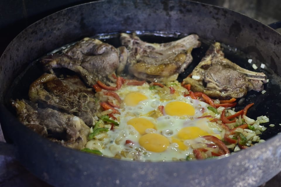 Steak, Ei und Gemüse werden noch über dem offenen Feuer gekocht.